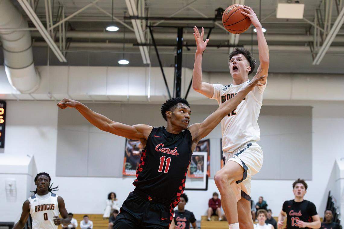 Douglass's Nate Coen (12) goes for the layup with GRC's Montez Gay (11) on defense during the George Rogers Clark vs Frederick Douglass game on Jan. 10, 2026, in Lexington, Ky.