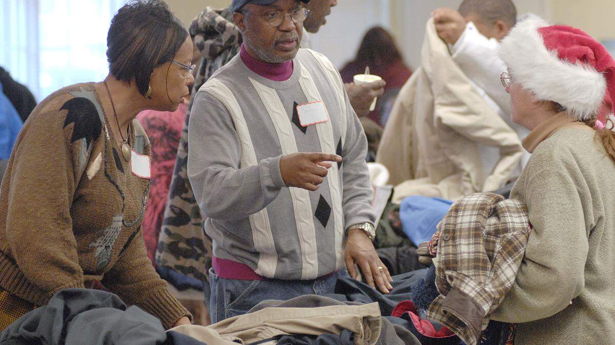 Lexingtonians Maxine Franklin, left, and her husband, the Rev. Norman Franklin, center, handed out coats and other warm clothing Sunday at the Lexington  Rescue Mission's ninth annual Christmas dinner. It was held at Broadway Christian Church.   
