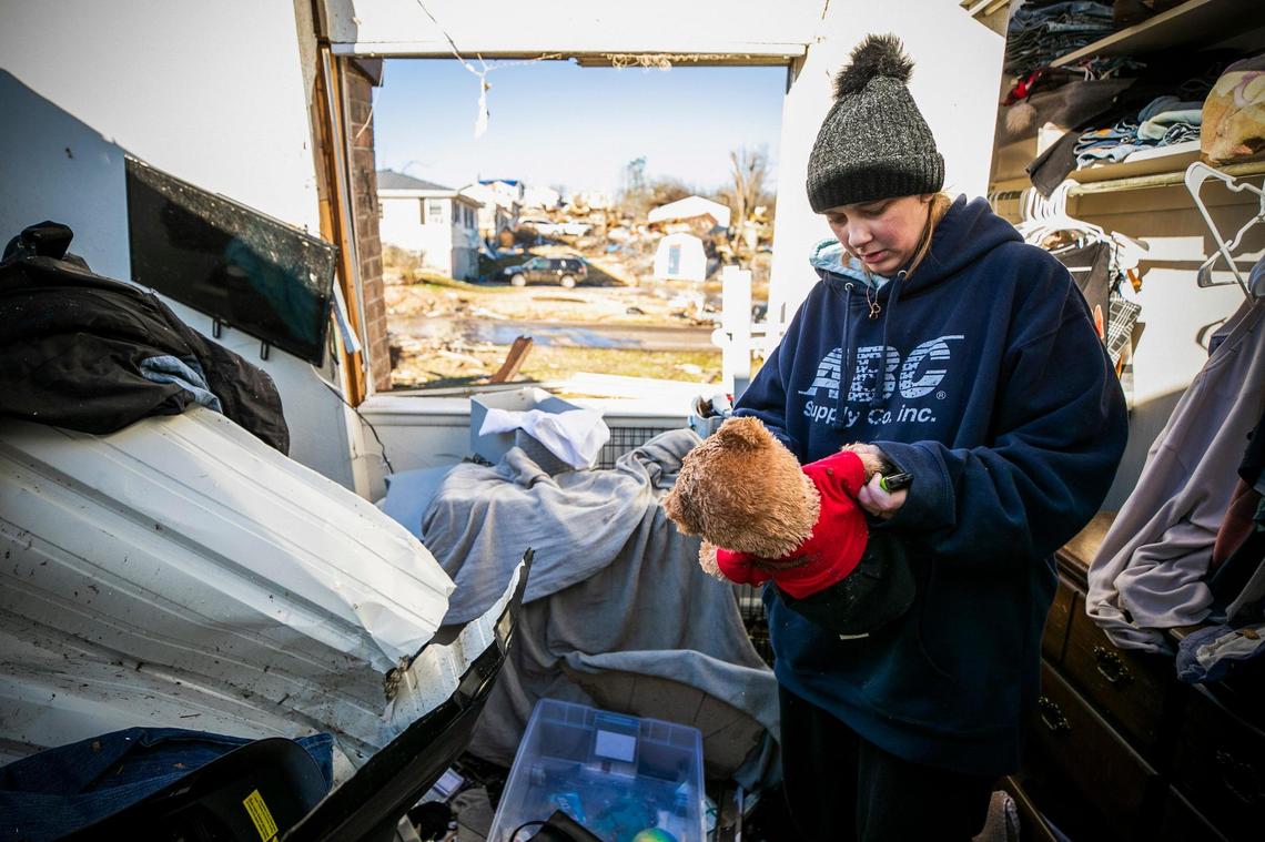 Kori Caldwell, of Dawson Springs, Ky., examines a teddy bear in the wreckage of her apartment in the Dawson Village complex in Dawson Springs, Monday, Dec. 13, 2021. Caldwell and her boyfriend Jerald Hancock were able to hide in her mother’s bathroom in a separate building during the tornado.