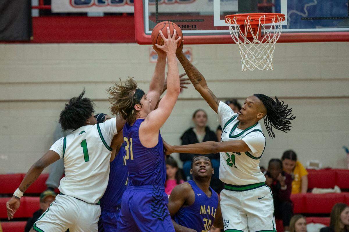 Male’s Jayson Gasaway (31) looked to score while Great Crossing’s Jeremiah Godfrey (21) and Vince Dawson (1) defended Saturday. Great Crossings defeated Male 65-63 at Scott County High School in the Dan Cummins Classic.