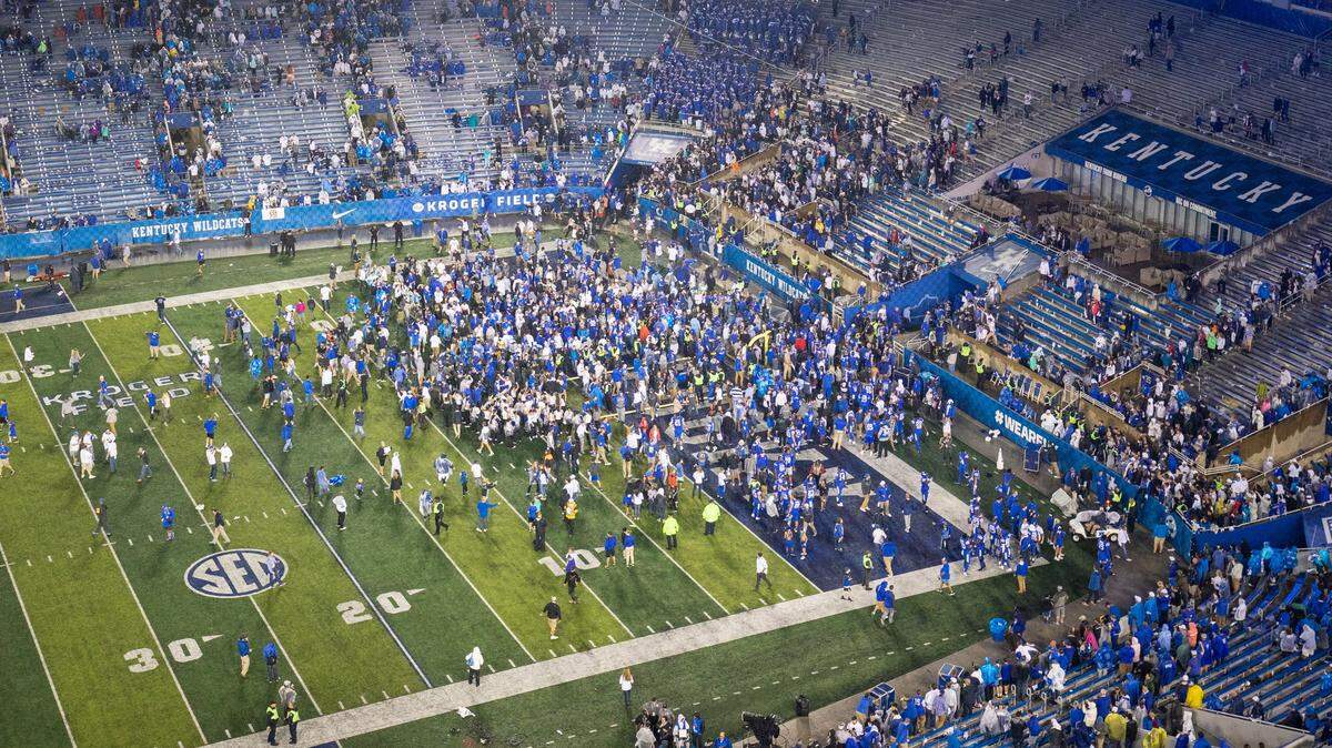 A few hundred fans joined Kentucky players on the field Saturday after UK topped No. 14 Mississippi State 28-7. The SEC is fining UK for fans being on the field, per league policy.