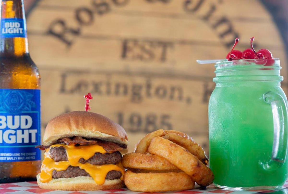 The beer cheese bacon at Rose & Jim’s Bar And Grill uses Kentucky Eagle’s MooShine beer cheese. It is shown with a side of onion rings and liquid marijuana, a popular drink from the bar.