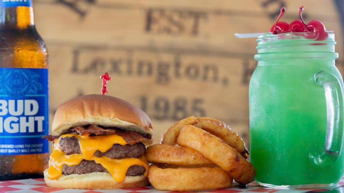 The beer cheese bacon at Rose & Jim’s Bar And Grill uses Kentucky Eagle’s MooShine beer cheese. It is shown with a side of onion rings and liquid marijuana, a popular drink from the bar.