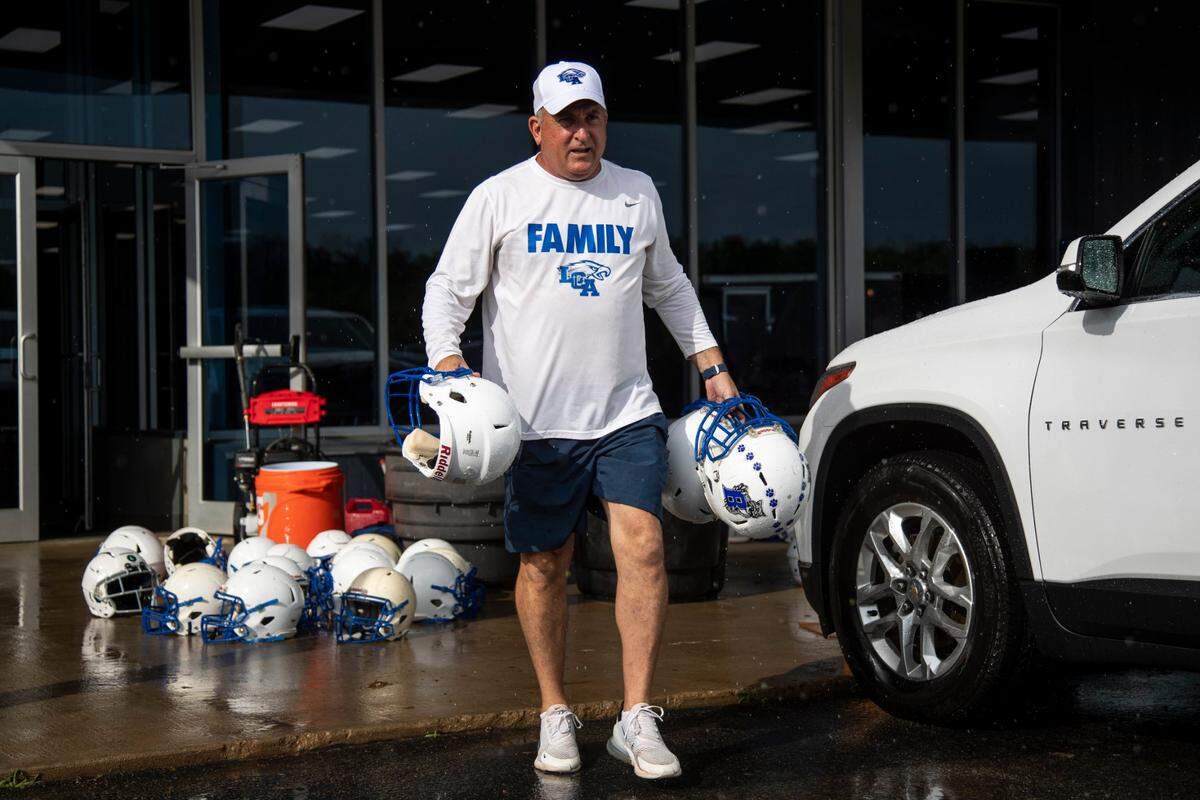 Doug Charles helped load helmets from Breathitt County’s flooded-out football facility into a trailer last month. Charles and his players traveled to Jackson after the devastating flooding in Eastern Kentucky to assist with cleanup efforts.