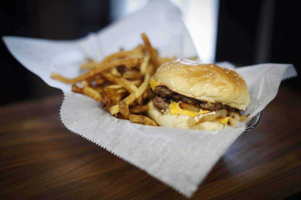 The Animal Style 1/4-pound burger topped with American cheese, caramelized onions and a signature sauce at Bazaar Eatery located inside Ethereal Brewing Public House.