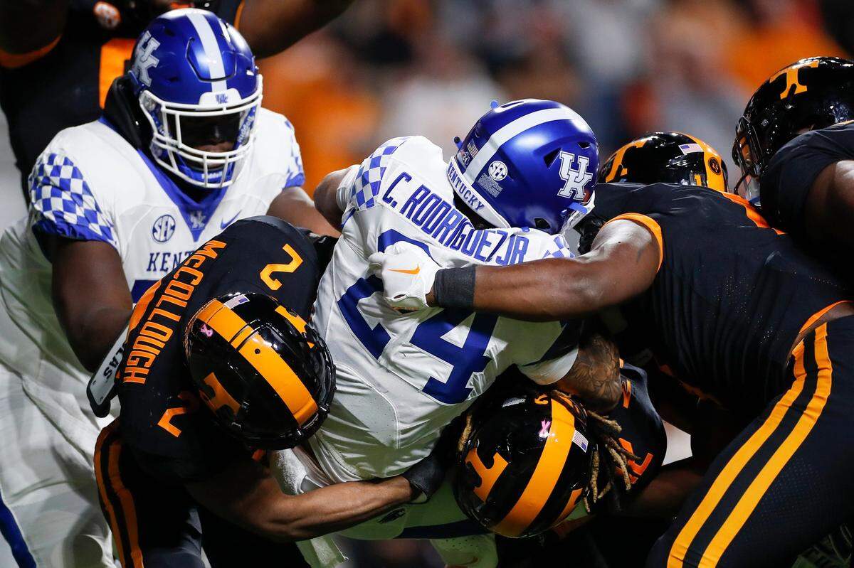 Kentucky running back Chris Rodriguez (24) is tackled by several Tennessee Volunteers on Saturday night. Rodriguez was limited to 64 yards rushing on 15 carries.