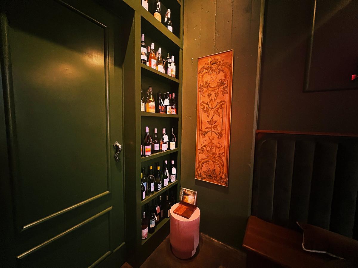 A quiet, dark little reading nook, tucked away in a corner, has a single beam of sunlight shine down upon it at the new speakeasy inside District 7 Social in Lexington’s Distillery District, called Book Club Wine Room at 1170 Manchester St #160 on May 23, 2025, in Lexington, Ky.