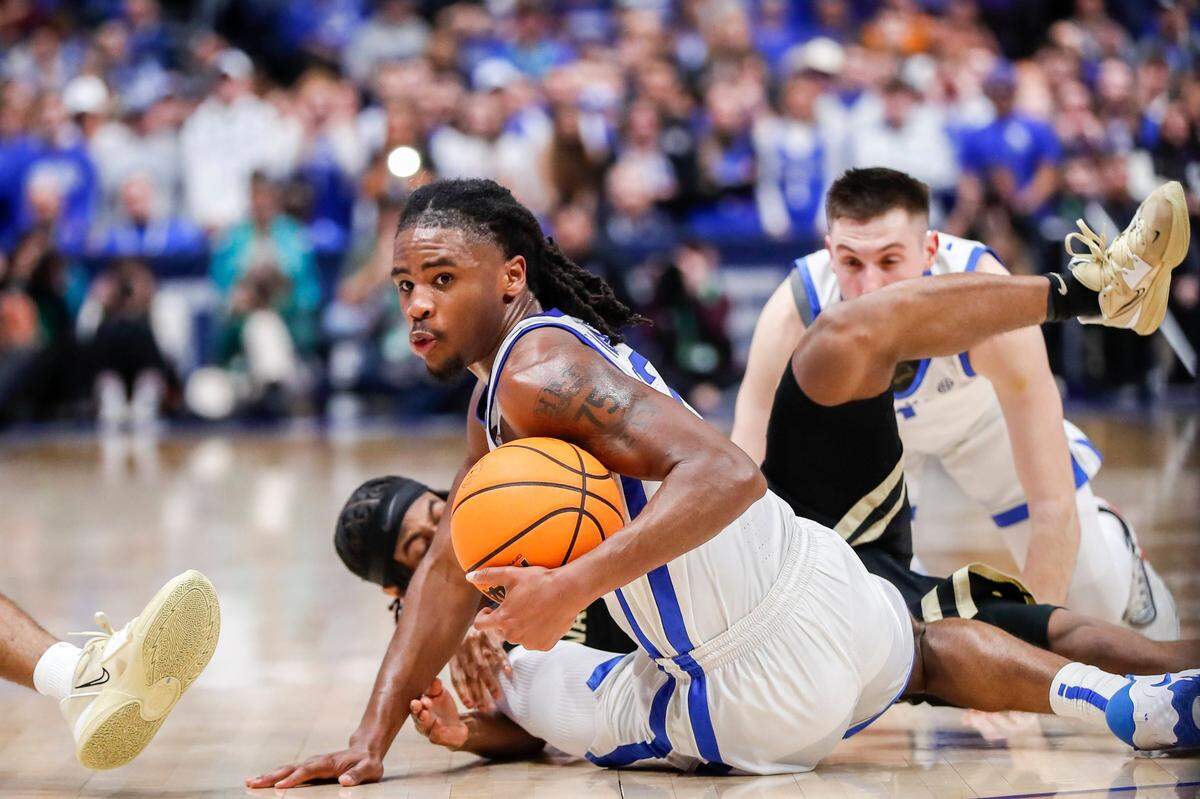 Kentucky guard Cason Wallace (22) grabs a loose ball against Vanderbilt during the SEC Tournament quarterfinals at Bridgestone Arena in Nashville on Friday.