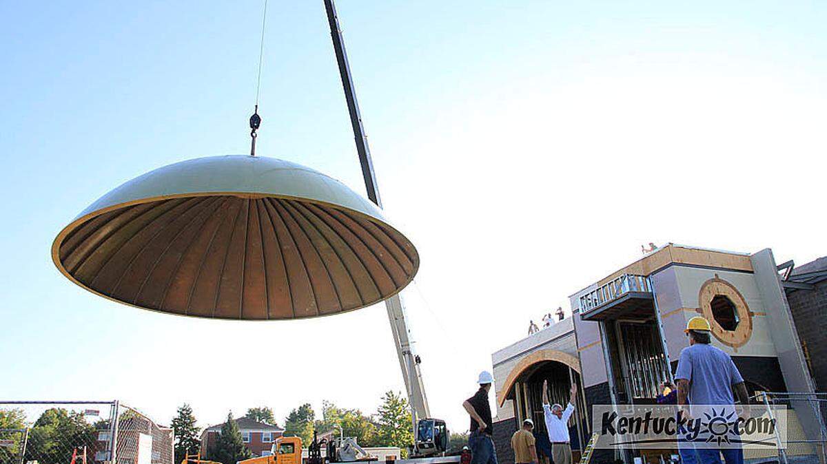 Developer Phil Greer, in the white shirt, celebrated Friday morning as workers with The Greer Cos. raised the dome of a planned restaurant in Idle Hour Shopping Center in Lexington. Photo by Ron Garrison | Staff