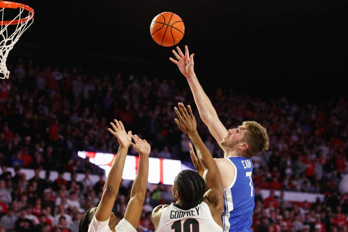 Kentucky’s Andrew Carr tries to score over a pair of Georgia defenders during Tuesday night’s loss in Athens. The Wildcats fell to 1-1 in SEC play and their next three opponents are top-15 teams.