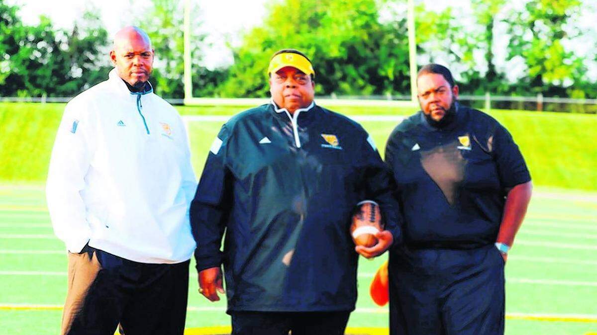 Alvis Johnson, center, with sons Dennis, left, and Derrick, at Woodford County High School, where the brothers have followed in their father’s coaching footsteps.