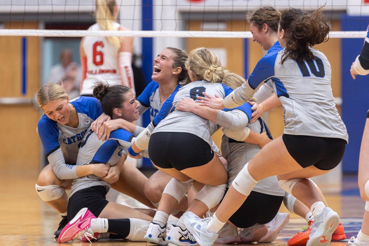 Lexington Catholic players swarm senior Addie Lowe, second from left, after she delivered the match-winning kill against Paul Laurence Dunbar in the 11th Region volleyball tournament championship at Madison Central High School in Richmond on Thursday.