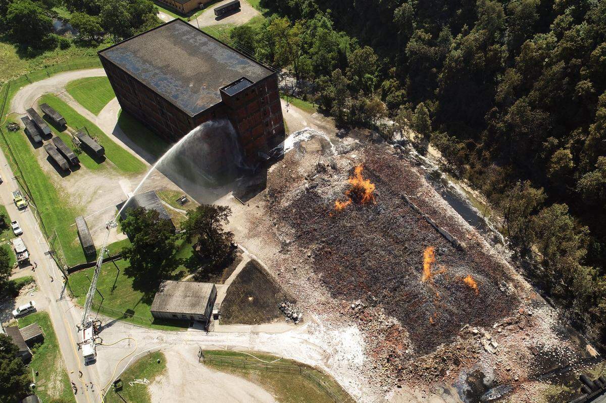 Crews continued to battle a fire at a Jim Beam bourbon warehouse Wednesday afternoon in Woodford County more than 12 hours after the fire began.