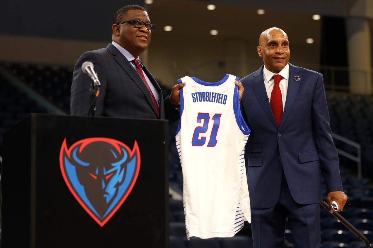 DePaul University’s new men’s basketball head coach Tony Stubblefield holds a jersey accompanied by Athletic Director DeWayne Peevy, left.