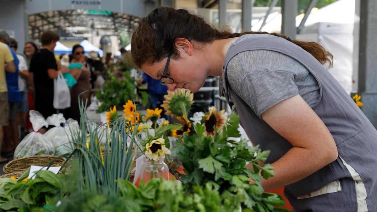 Julia Hall writes in a ledger after selling items from Stonehedge Farm on Saturday, June 17, 2023 at the Fifth Third Pavilion in Lexington, Ky.