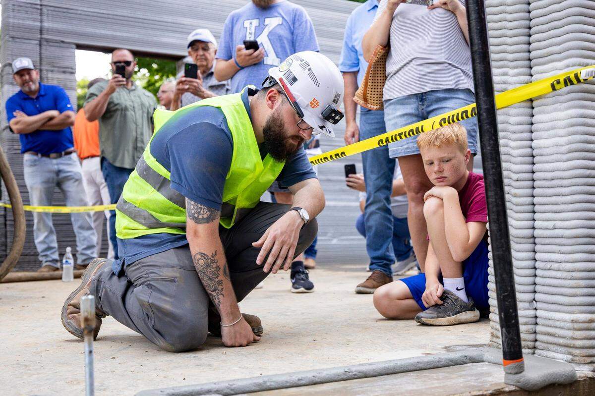 Andrew Clapper, a project manager, watches concrete pour from the programmed nozzle on Friday, June 27, 2025, at the Somerset Community College Valley Oak Center in Somerset, Ky.