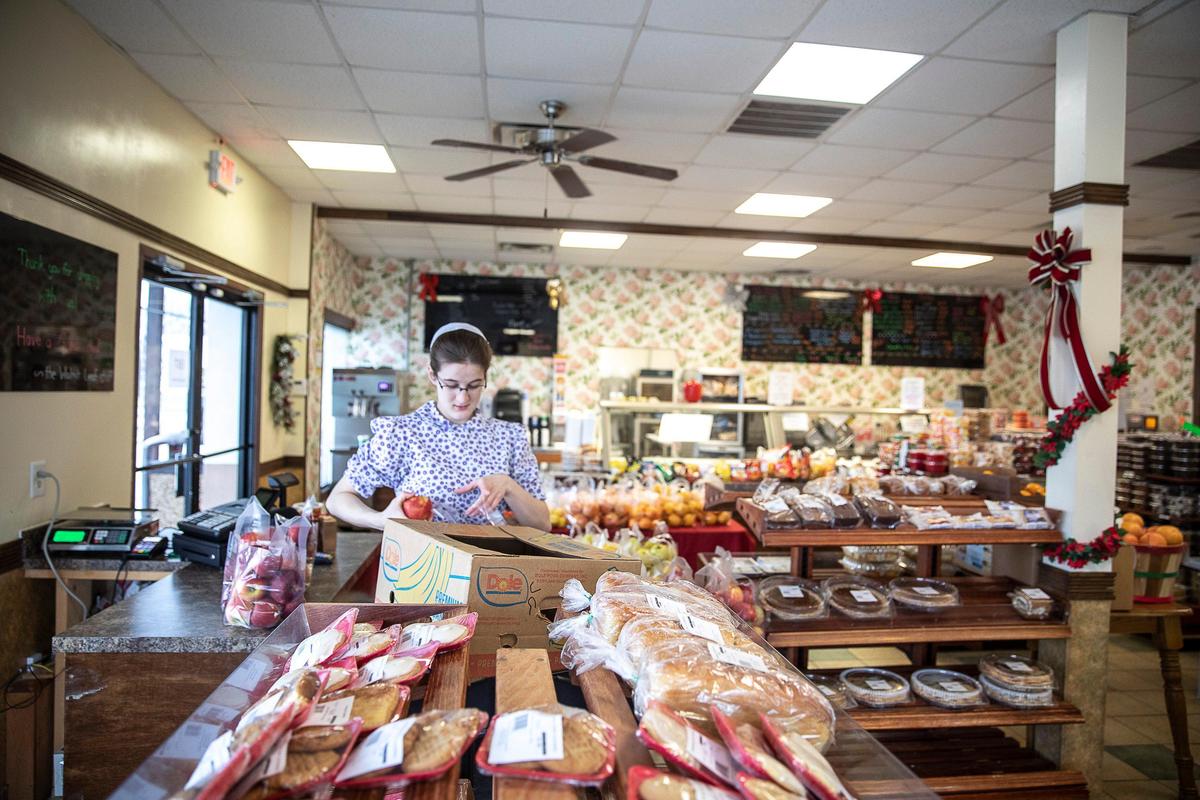 Angela Gerber unpacks apples at Walnut Leaf Country Market at 4004 Camargo Rd. in Camargo, Ky., on Tuesday, Feb. 18, 2020.