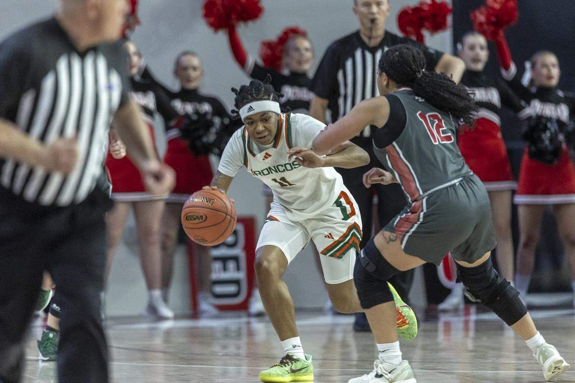 Frederick Douglass' Mikalee Bennett (11) drives the ball as Paul Laurence Dunbar's Eriyaune Daniels (12) defends during the Girls 11th Region Tournament championship game at Eastern Kentucky University's Baptist Health Arena in Richmond, Ky., on Sunday, March 8, 2026.