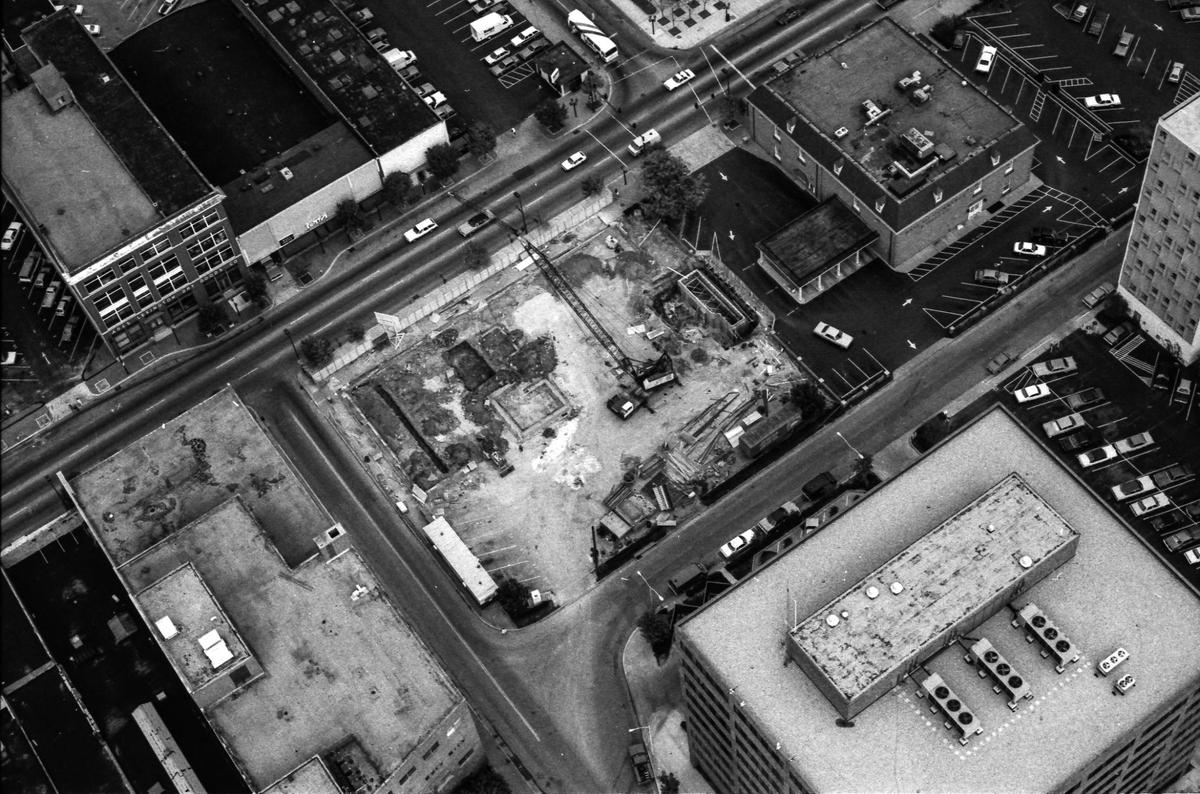 Construction of what would become a five-story, 55,593 square-foot office building Oct. 4, 1982. Behind it in the lower right corner is the headquarters of Kentucky Utilities, who moved into this location three years earlier. To the right of the construction site is the Bank of Commerce and Trust Company. The road running diagonal from right to left is East Main Street and in the upper left corner is the Ades-Lexington Dry Goods Co. building. In 1977, the Ades family discontinued the dry goods business, and the building became a warehouse.