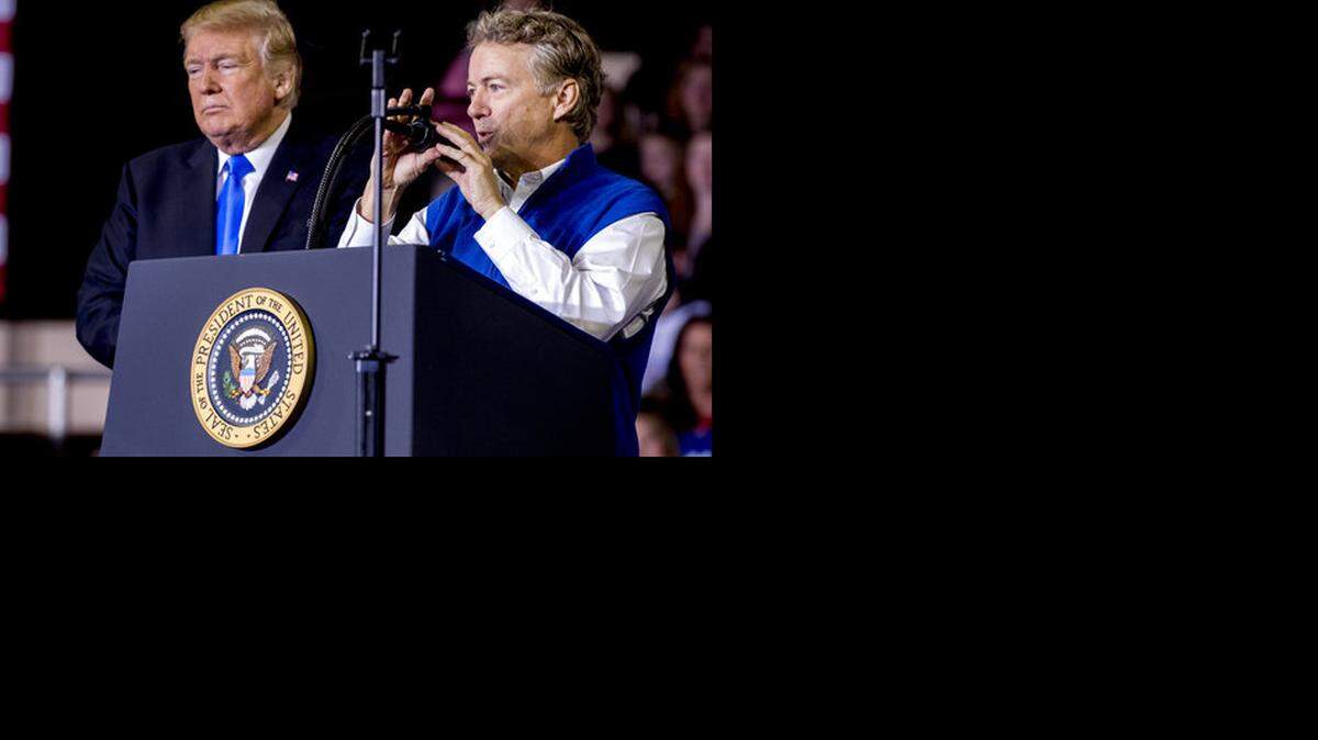 President Donald Trump, left, listened as Sen. Rand Paul, R-Ky., right, spoke at a rally at Alumni Coliseum in Richmond Saturday, Oct. 13, 2018.