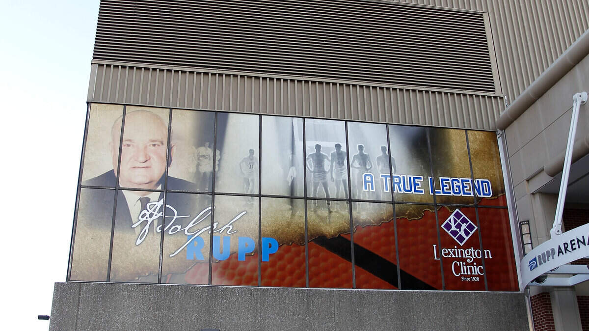Rodney Grey, with the Lexington Center, cleaned the sidewalk under a banner honoring former UK basketball coach  Adolph Rupp outside Rupp Arena on West High Street near South Broadway in Lexington, Ky., Friday, October, 14, 2011. Rupp Arena opened in 1976. Charles Bertram | Staff