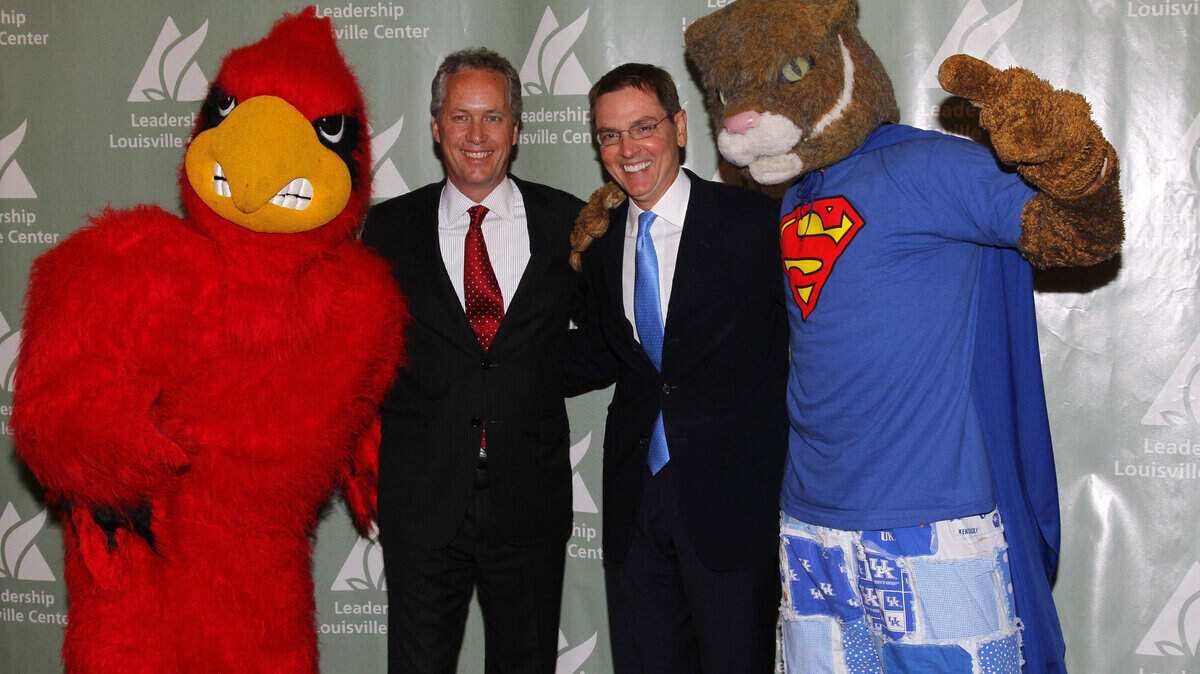 Lexington Mayor Jim Gray, right, and Louisville Mayor Greg Fischer posed with their respective university mascots during a Leadership Louisville luncheon Thursday. The mayors discussed an economic development initiative that would be assisted by the Brookings Institution.