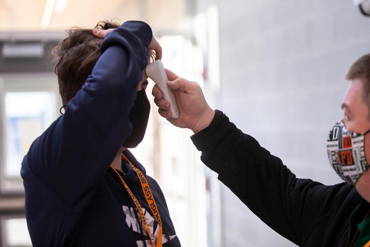 A students has his temperature checked while entering the school during the first day returning to in-person learning at Frederick Douglass High School in Lexington, Ky, Monday, March 8, 2021. Close to 80 percent of the student body chose to return to in-person learning while 20 percent remain virtual.