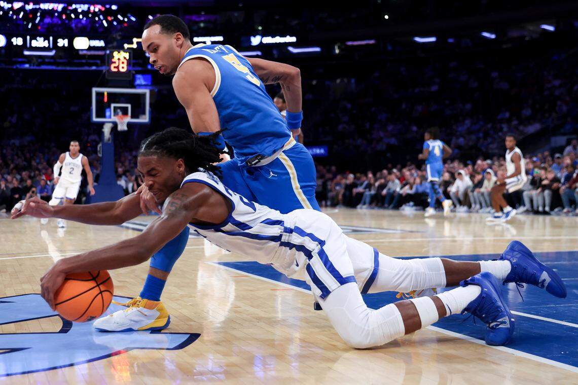 Kentucky’s Cason Wallace and UCLA’s Amari Bailey (5) lunge for the ball during the first half in the CBS Sports Classic on Saturday in New York.