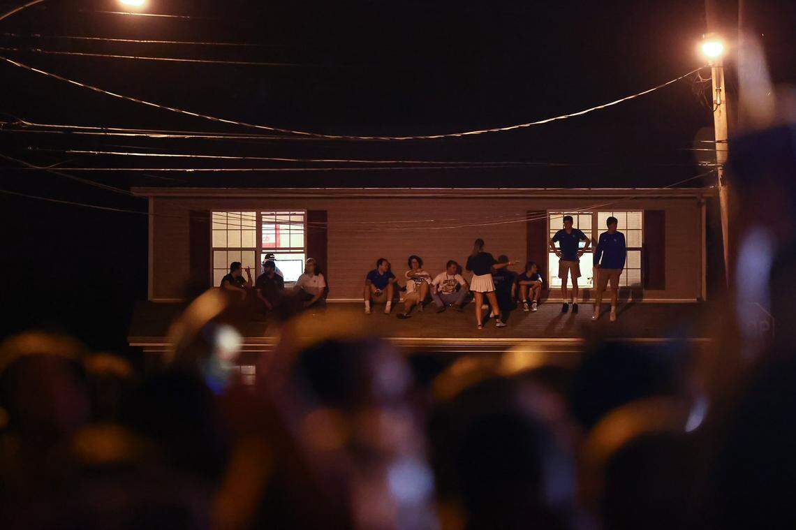 Students stand on the roof of porches in the State Street area after UK’s win over LSU on Oct. 10, 2021.