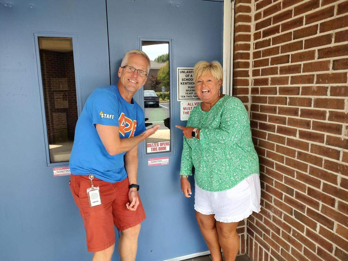 Aaron Dowdell, left, a mental health specialist at Rosa Parks Elementary School, and Rosa Parks Principal Claudine Barrow posed with a Green Dot Spot sticker at the entrance to the school.