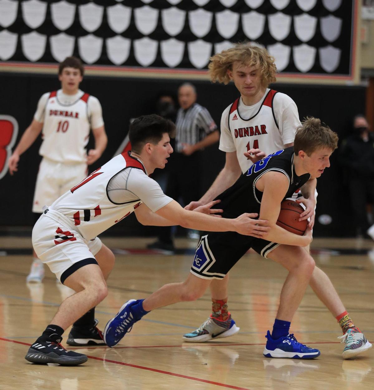 Paul Laurence Dunbar’s Max VanDyke (31) fought to get the ball from Lexington Catholic’s John Reinhart (22) during the Knights’ 61-56 win over the Bulldogs.