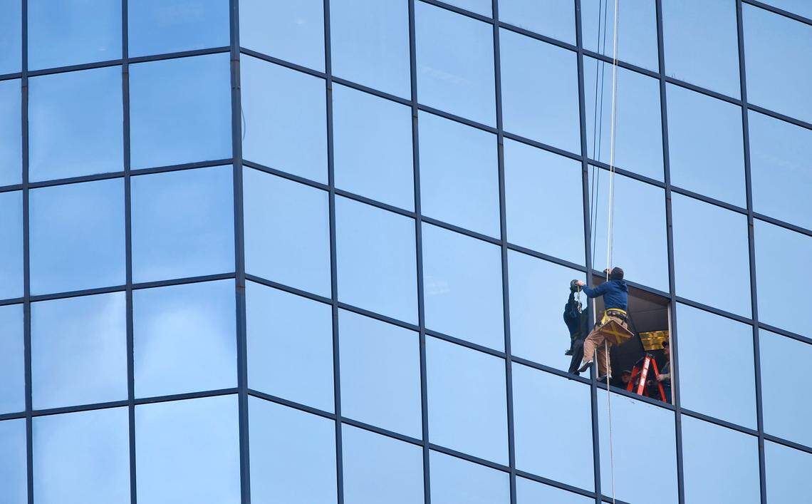 Grant Robinson, with Gott Caulking, worked from a bosun’s chair Thursday, Jan. 10, 2019, as he and employees with O’Nan Glass & Window Company replaced the pane of glass that was damaged by a bullet earlier in the week at the Lexington Financial Center.