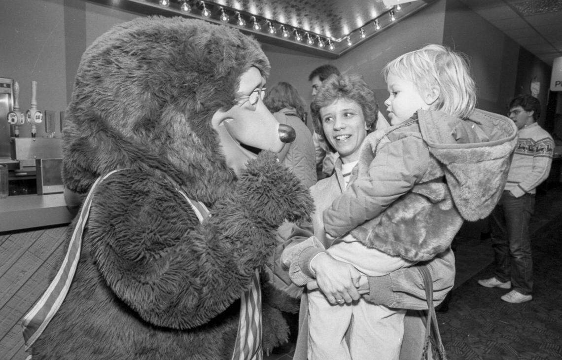 Billy Bob, the ShowBiz Pizza Place mascot bear greets a  kid, Wednesday, Jan. 4, 1984 at the Woodhill Circle Plaza pizza restaurant in Lexington, Ky. To his left are several beer taps including Miller Lite and Miller High Life. In 1991 the restaurant was rebranded Chuck E. Cheese and in 2025 it closed. Photo by Christy Porter, Herald-Leader file photo