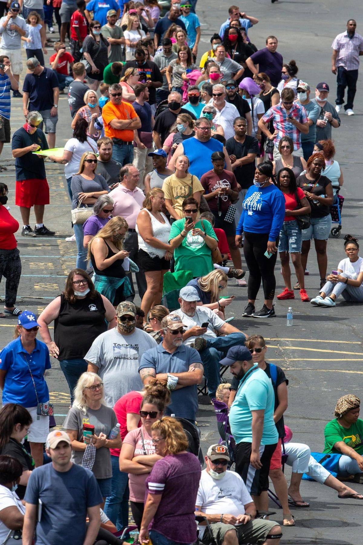 Hundreds of people wait in line for assistance with their unemployment benefits outside the Kentucky state Capitol in Frankfort, Ky., on Wednesday, June 17, 2020.