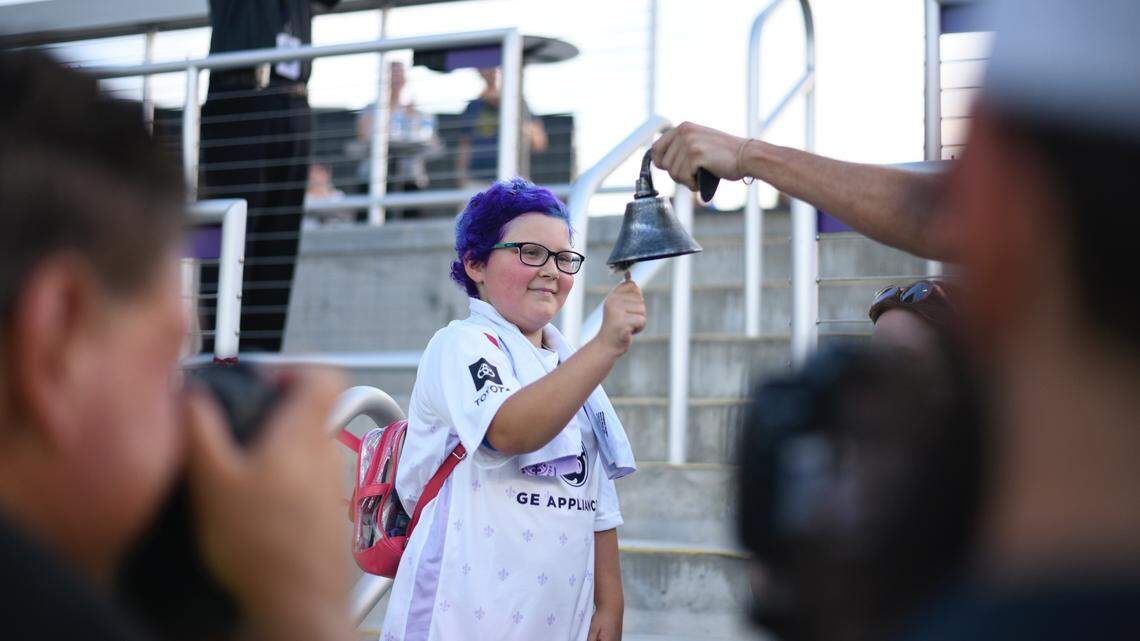 Ellie Hurley “rings the bell” to celebrate the end of chemotherapy at Sunday’s Racing Louisville Football Club game against the Washington Spirit. Photo courtesy of Connor Cunningham.