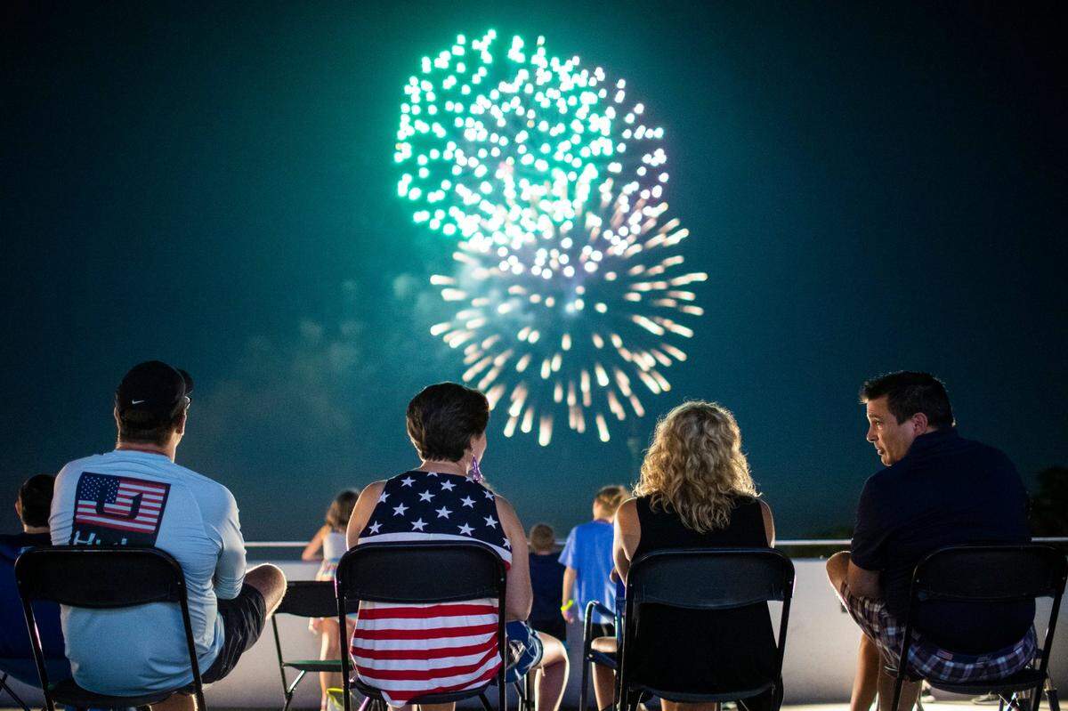 People relax and separate the city’s firework show from the R.J. Corman Railroad Group facilities on the corner of Main Street and Oliver Lewis Way celebrating Independence Day in Lexington, Ky., Monday, July 4, 2022.