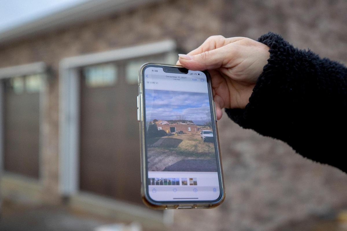 Margaret Whitmer holds a phone on Thursday, Feb. 2, 2023, showing a picture of her home near Millport, Ky., that was destroyed by a tornado on Dec. 10, 2021. Construction is underway on a new home at the site.