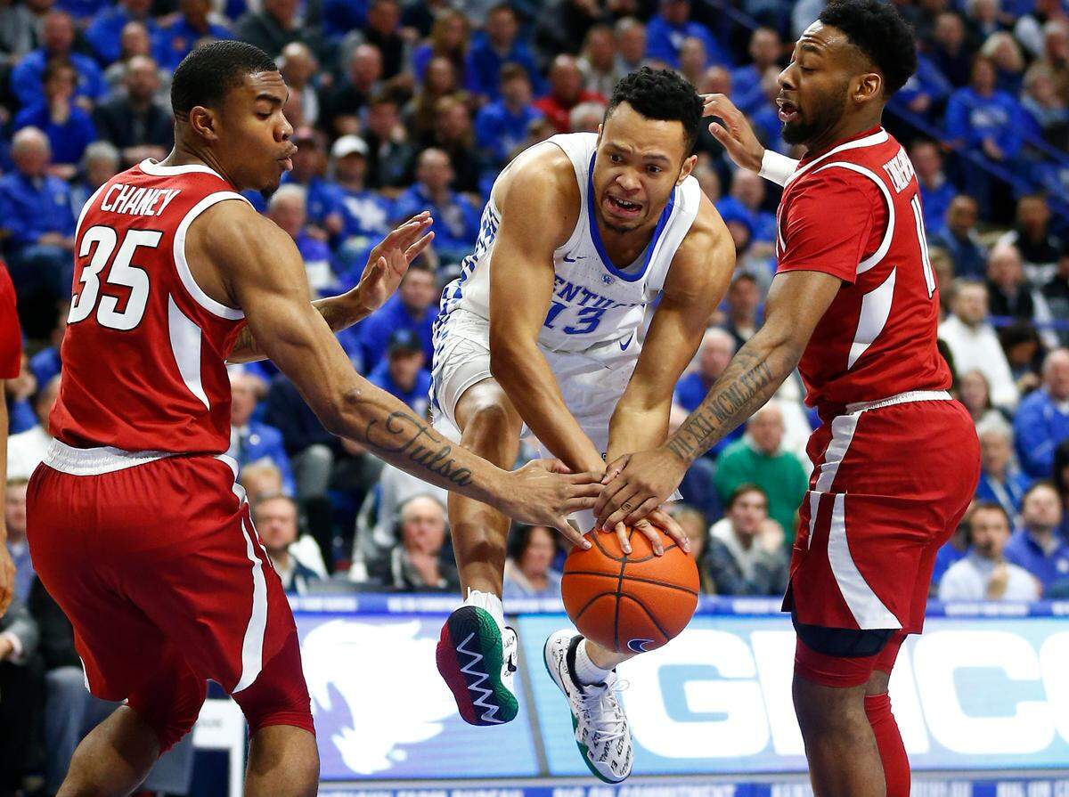 Kentucky’s Jemarl Baker got caught between Arkansas defenders Reggie Chaney (35) and Keyshawn Embery-Simpson (11).