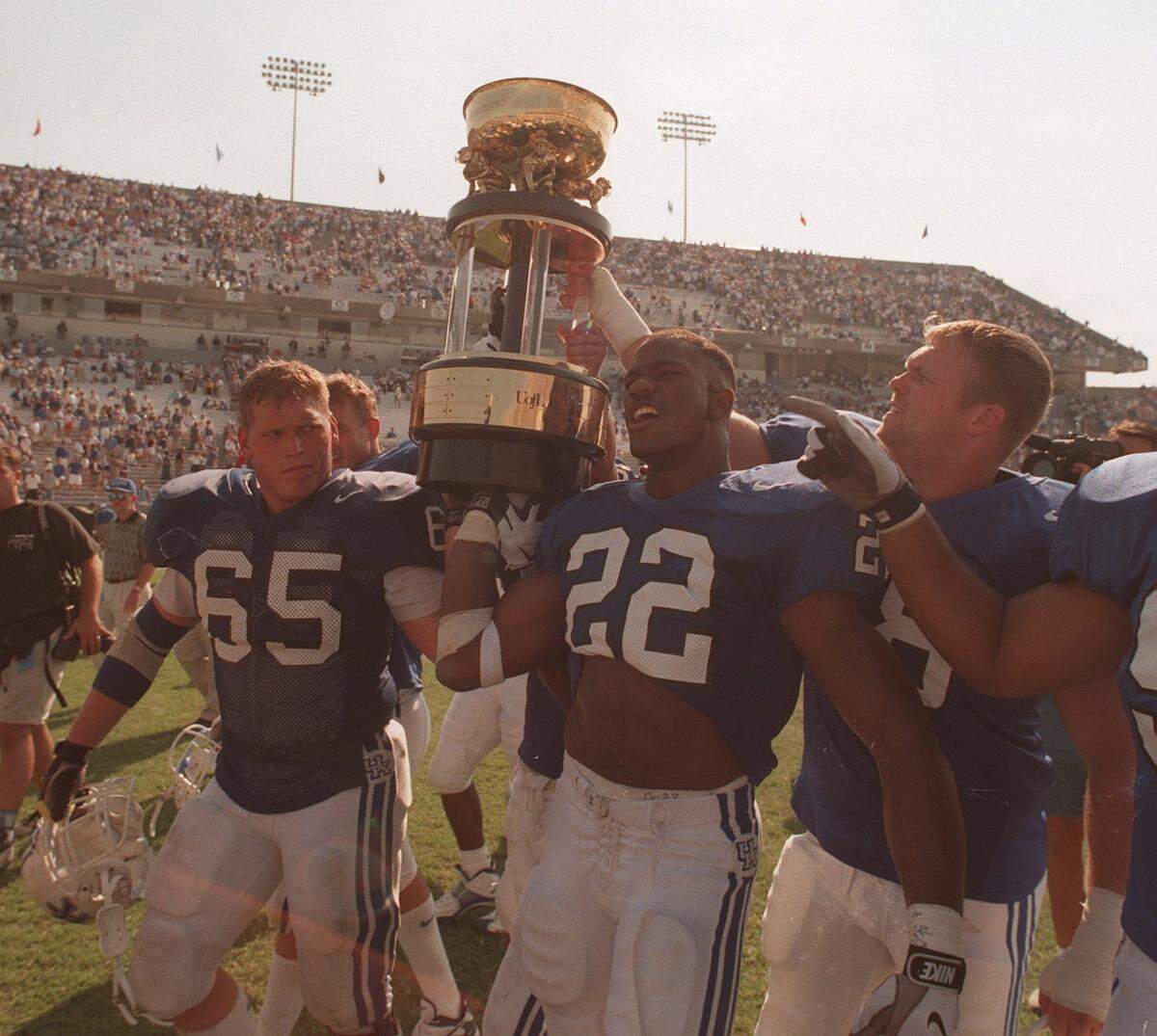 Kentucky football’s John Schlarman (65) and Dele Ali (22) hoisted the Governor’s Cup trophy after UK beat Louisville 38-24 in the 1997 Wildcats-Cardinals rivalry game. The 2023 Cats will have to pull a massive upset of the No. 9 Cards to retain the Governor’s Cup for a fifth straight time.