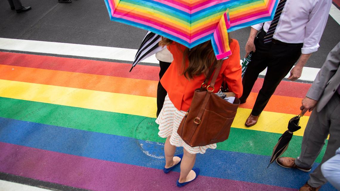 City officials, reporters and members of the public stand on freshly painted rainbow cross walk at the intersection of North Limestone and Short Street before a press conference by Mayor Linda Gorton and former Mayor Jim Gray in Lexington, Ky., Monday, June 7, 2021.