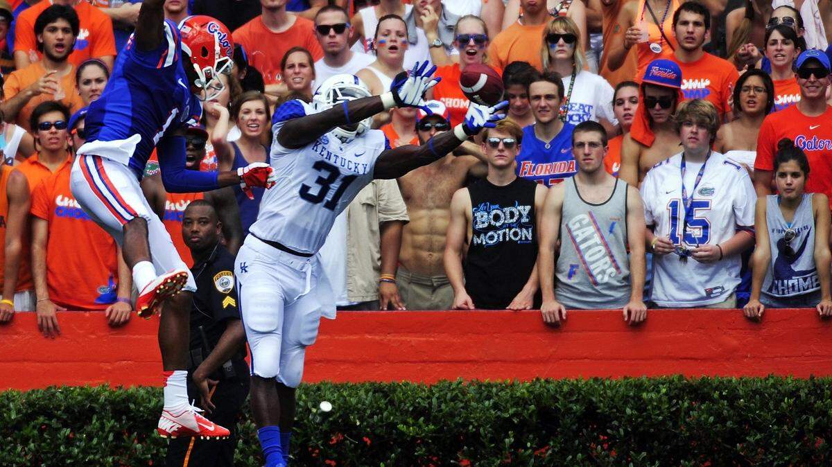 Kentucky Wildcats safety Mikie Benton (31) reaches for the ball in front of Florida Gators wide receiver Quinton Dunbar (1) in the second quarter as the #14 Florida Gators beat the Kentucky Wildcats 38-0 in an NCAA Football Game on Saturday, September 20, 2012 at Ben Hill Griffin Stadium in Gainesville, Fla. (David Manning for The Lexington Herald-Leader)