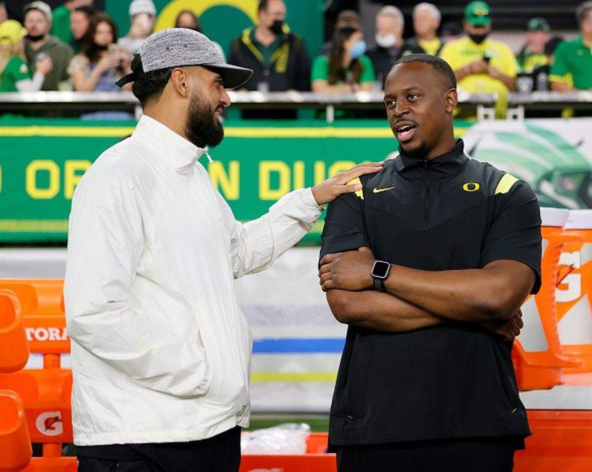 LAS VEGAS, NEVADA - DECEMBER 03: Quarterback Marcus Mariota (L) of the Las Vegas Raiders, a former quarterback for the Oregon Ducks, talks with Director of Player Development Tony Washington Jr. of the Ducks before the Pac-12 Conference championship game between the Ducks and the Utah Utes at Allegiant Stadium on December 3, 2021 in Las Vegas, Nevada. The Utes defeated the Ducks 38-10. (Photo by Ethan Miller/Getty Images)