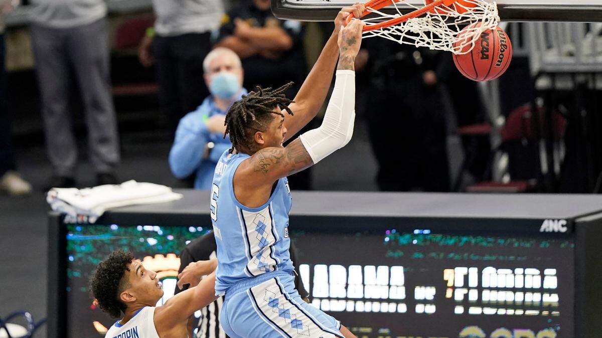 North Carolina’s Armando Bacot (5) dunked past Kentucky’s Jacob Toppin (0) in the second half Saturday in Cleveland. Bacot led the Tar Heels with 14 points and also grabbed eight rebounds.