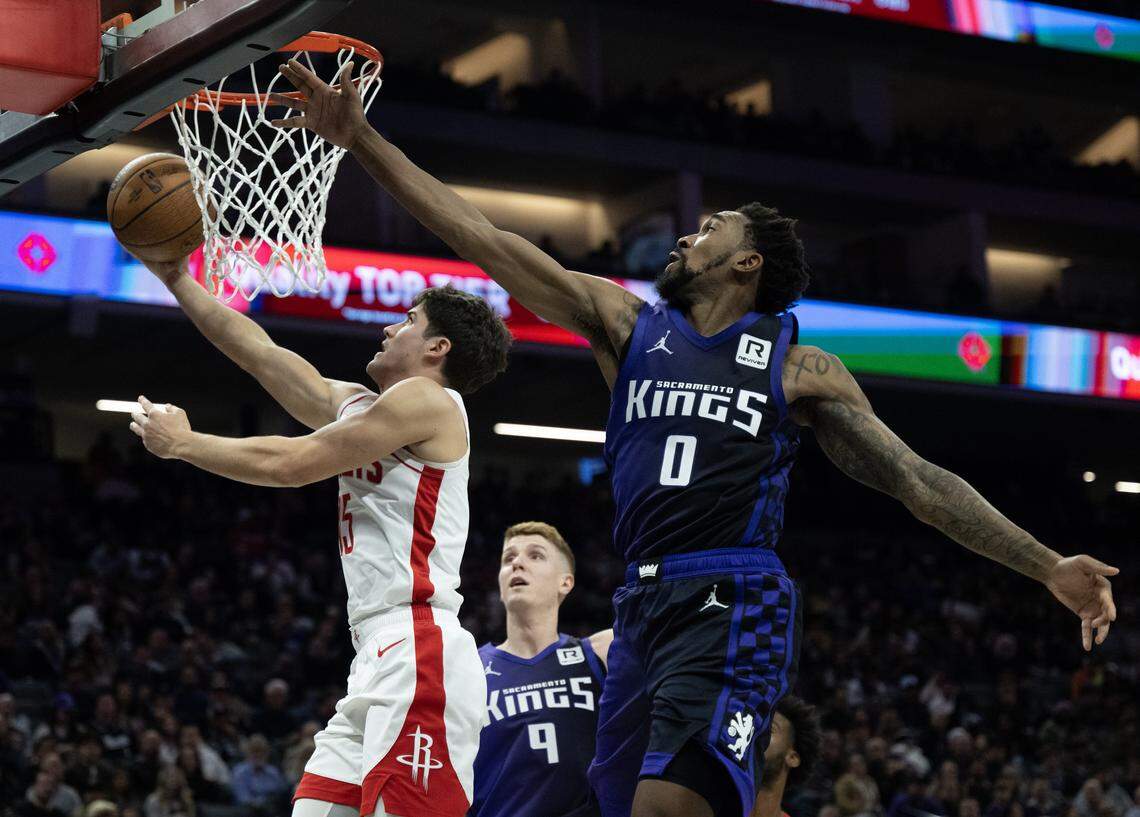 Houston Rockets guard Reed Sheppard, left, attempts a layup while guarded by Sacramento Kings guard Malik Monk (0) on Dec. 3, 2024.