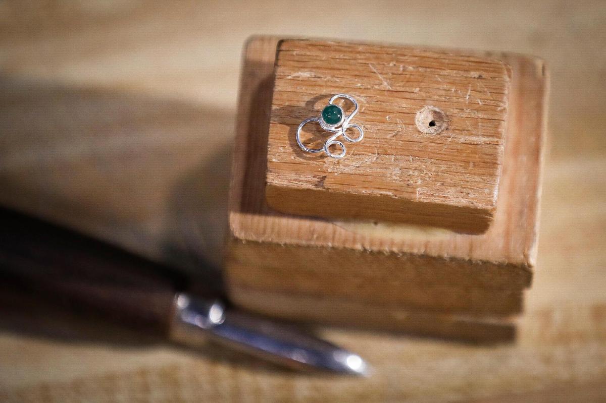 A ÔcompassionÕ mask pin with an aventurine gemstone at SavanŽ Silver in Lexington, Ky., Thursday, Dec. 17, 2020.