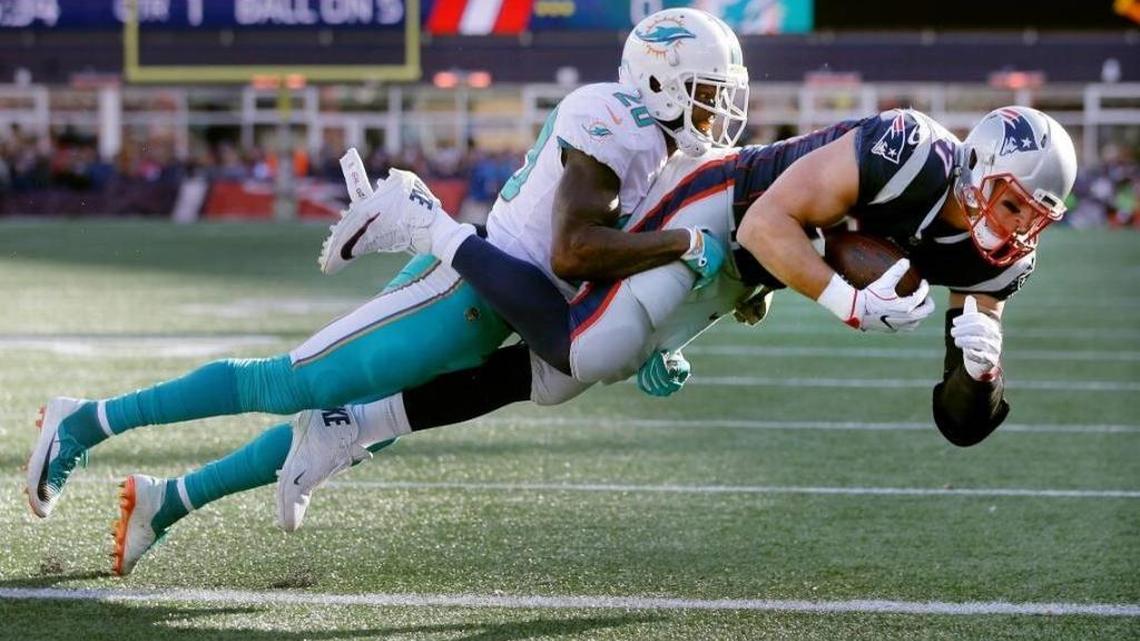 The Pats’ Rob Gronkowski carries Dolphins safety Reshad Jones into the end zone in a 35-17 New England win over Miami last November in Foxborough, Mass.