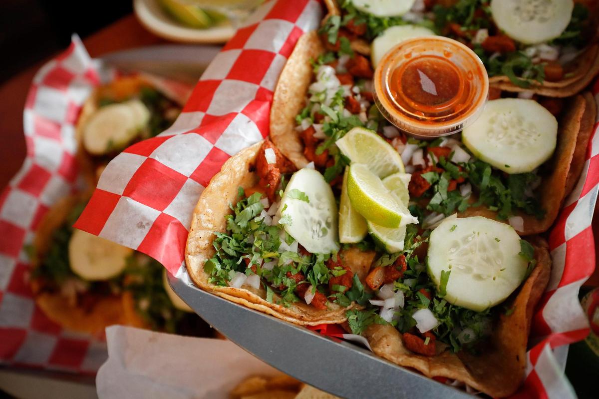 A platter of fresh tacos including steak, chicken, chorizo, ground beef, chicken, tripe, cheek and tongue at Cilantro Grilled Food and Tacos in Paris.