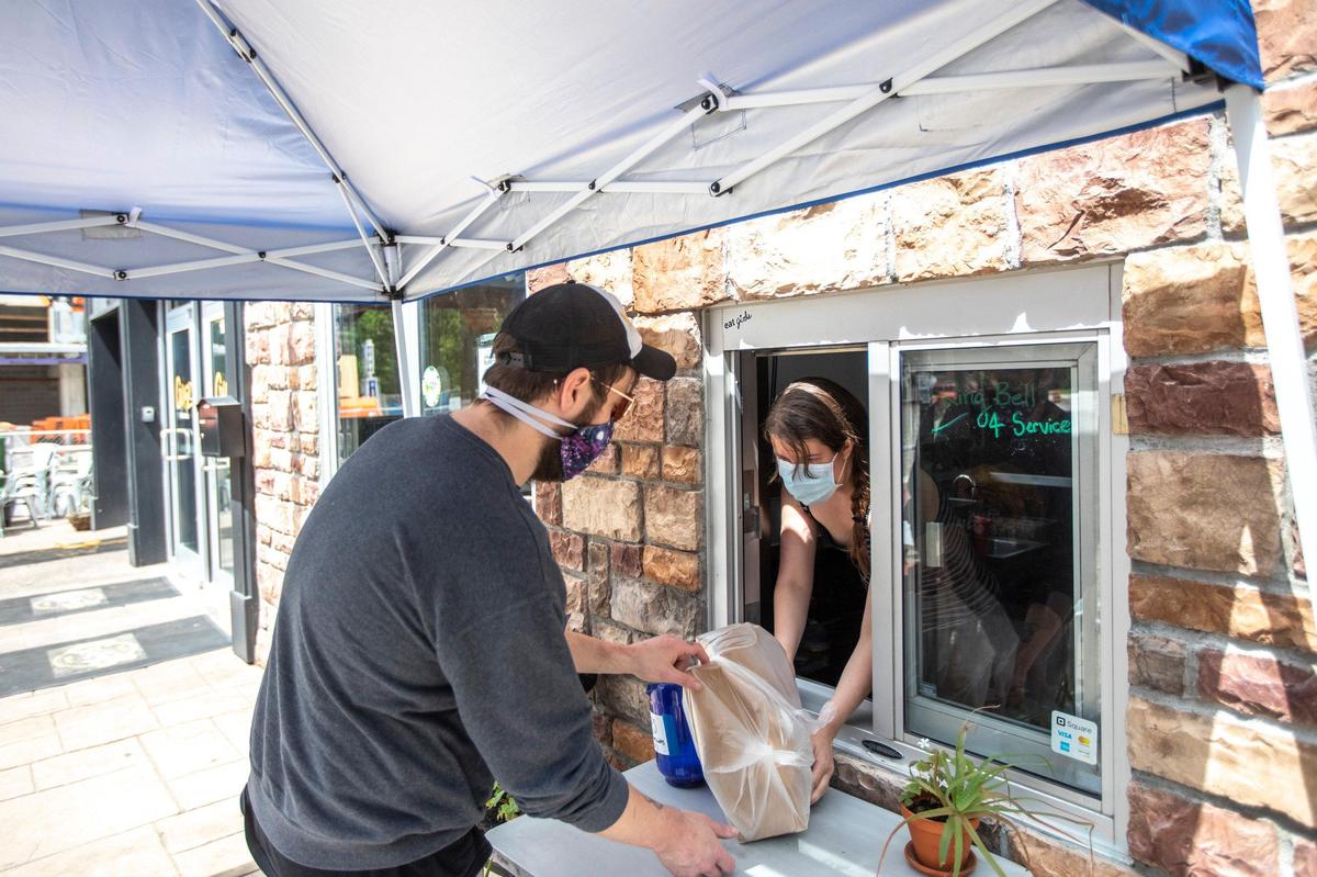 Larry Bance picks up two burritos Friday at GirlsGirlsGirls Burritos at 395 S. Limestone. Restaurants in Kentucky could reopen to dine-in customers Friday.