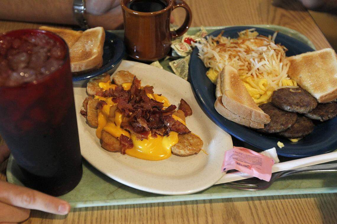 The regular meal for Jay Walters and his dad Joe Walters during the lunchtime rush at the new location of the Tolly-Ho, 606 S Broadway in Lexington, Ky., Thursday, May 19, 2011. After being on South Limestone for 25 years, the popular restaurant reopened at 6 a.m. this morning at the new location. Joe first ate at Tolly-Ho when he was a freshman at UK in 1977. He brought Jay there in 1987, the year he was born. Jay eats chicken nuggets covered in cheese sauce and bacon-Joe always eats breakfast food for lunch. Charles Bertram | Staff......