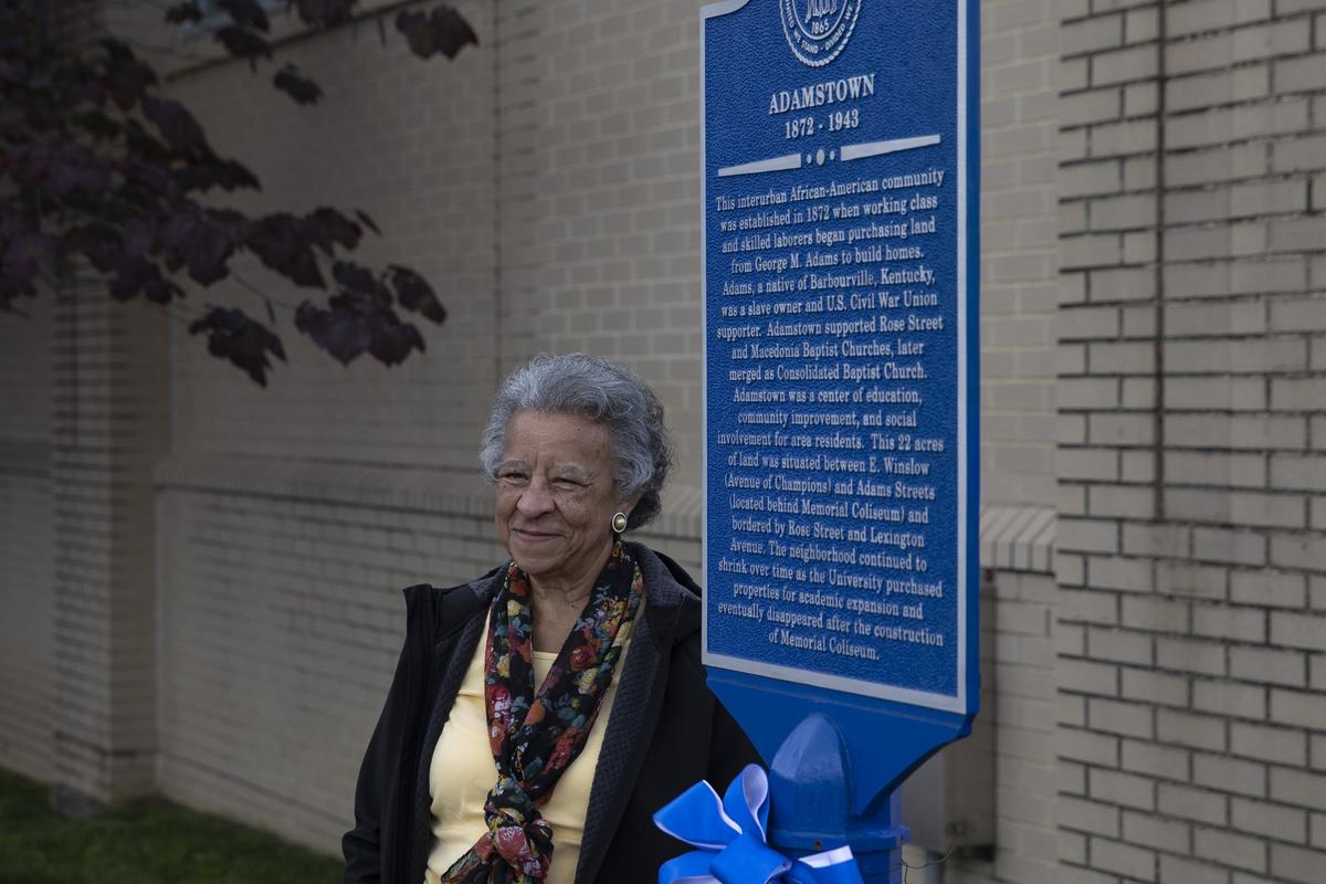 Yvonne Giles, of Lexington, poses for a photo next to a historical marker after it was unveiled Tuesday, May 14, 2019, on the University of Kentucky campus to commemorate the black neighborhood that was torn down to make way for Memorial Coliseum.